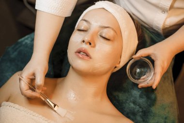 Sevimli bir genç kadının üst görünümü üzerinde bir anti akne maskesi olan 