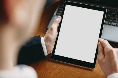 Otururken beyaz ekranlı bir tablet kullanarak erkek elinin kapatılması