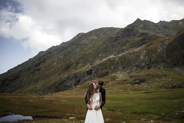 Młoda Kaukaska para małżeństw obejmując góry, podczas gdy — Zdjęcie stockowe