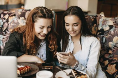 Bir akıllı telefon scre bakarak iki neşeli kız arkadaşı Portresi