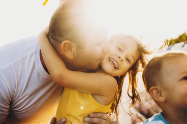 Öpüldüğü sırada gülen güzel bir küçük kızın portresi 