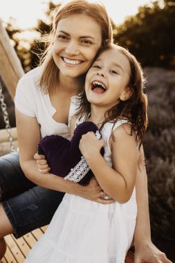 Bir anne ve kız kucaklayan ve woode üzerinde oturan Portresi