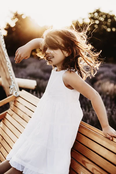 Retrato de uma linda menina dançando no vento contra — Fotografia de Stock