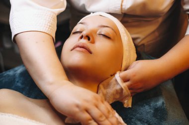 Yetişkin beyaz kadın kuyuda cilt bakımı yapıyor.