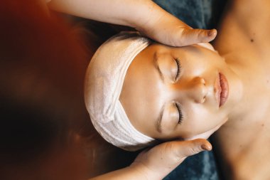 Charming young caucasian woman doing skin care face routine in a