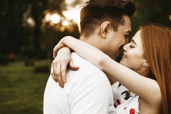 在城市里 一对令人惊叹的高加索夫妇在紧闭双眼亲吻日落前拥抱和微笑的侧景画像 — 图库照片