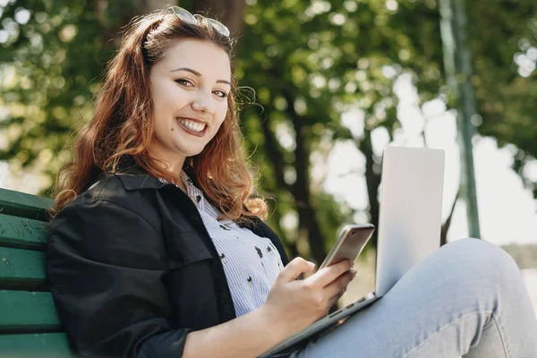 Porträtt av en charmig plus size kvinna sitter på en bänk med en — Stockfoto