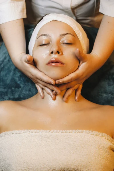 Güzel beyaz bir kadının boyun masajı yaptırdığı bir fotoğraf.