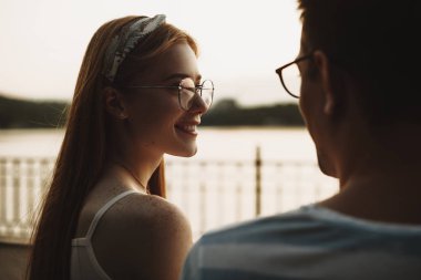 Çilli, kızıl saçlı, genç bir kadının yan görünüşü.