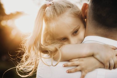 Küçük tatlı kız babasına sarılıyor.