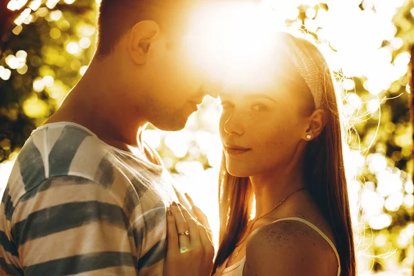 Tiro ao ar livre de jovem casal abraçando contra o pôr do sol. Encantador yo — Fotografia de Stock