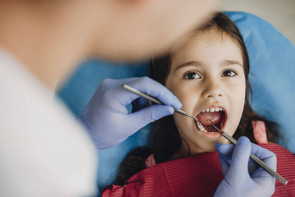 Close up of a happy cute kid doing a tooth examination in a pediatric stomatology.