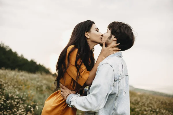 Outdoor shot of a romantic couple kissing outdoor. Lovely young caucasian man and woman embracing and kissing while dating.