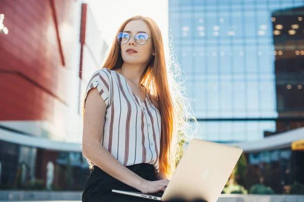 Πολυάσχολος καυκάσιος επιχειρηματίας με διαβασμένα μαλλιά και φακίδες που φοράει γυαλιά και εργάζεται στο laptop έξω — Φωτογραφία Αρχείου