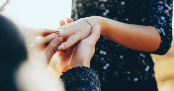 Homem caucasiano de joelhos pedindo casamento sua namorada enquanto colocando em seu dedo o anel de casamento — Fotografia de Stock