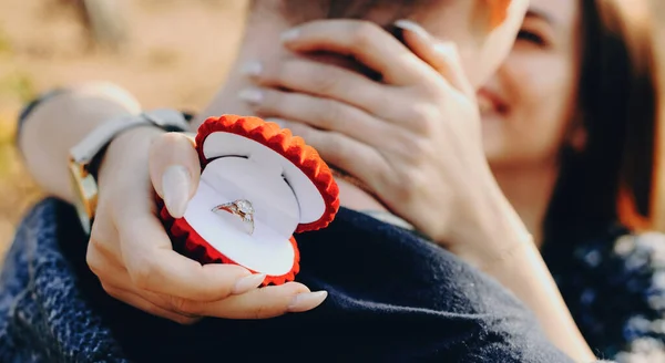 向一个被他未来的妻子拥抱着红戒指盒的高加索男人求婚成功 — 图库照片
