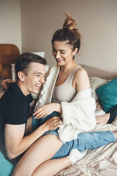 Adorável casal caucasiano abraçando e brincando na cama enquanto sorri — Fotografia de Stock