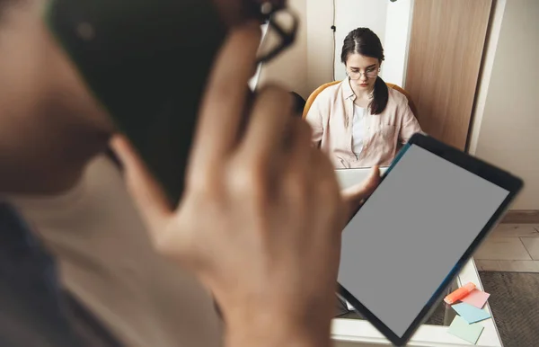 Close up photo of a young business couple working remotely from home using a tablet with free space and talking on phone — Stock Photo, Image