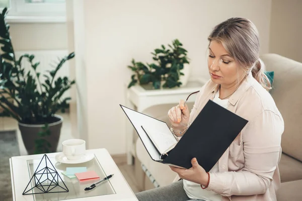 Senior blonde caucasian woman working with some documentation from home — Stock Photo, Image