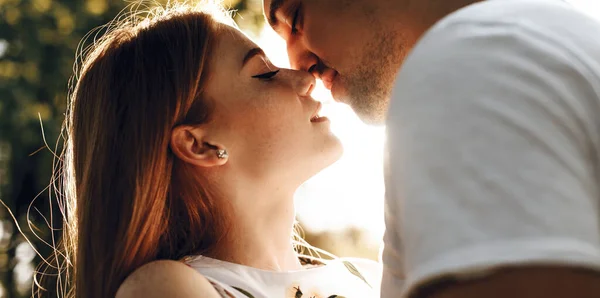 Kaukasische Dame mit roten Haaren und Sommersprossen, die ihren Liebhaber im Licht der Sonne umarmt und küsst — Stockfoto