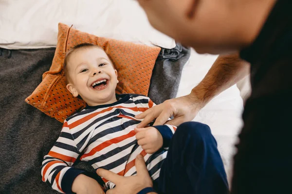 Caucasiano pai e filho se divertindo no sofá juntos durante o fim de semana rindo feliz para a câmera — Fotografia de Stock