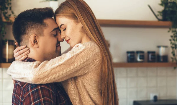 Bella donna zenzero con lentiggini abbracciato dal suo amante ha un momento intimo in cucina — Foto Stock