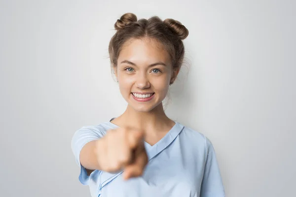 Lächelnde Kaukasierin, die mit dem Finger auf eine weiße Studiowand zeigt — Stockfoto