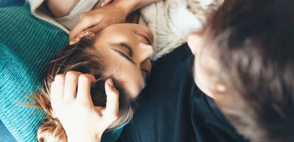 Schöne junge Kaukasierin liegt auf ihrem Freund und lächelt mit geschlossenen Augen auf dem Sofa — Stockfoto