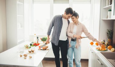 Güzel beyaz bir çift mutfakta meyve salatası hazırlıyor.