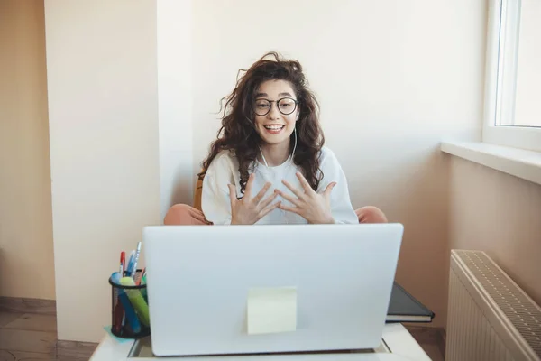 Lockig ung student på online lektioner bär glasögon och hörlurar som uttrycker framför den bärbara datorn — Stockfoto