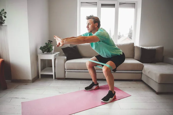 Uomo caucasico stretching e riscaldamento a casa mentre fa fitness — Foto Stock