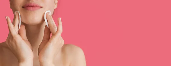 Close-up foto van een blanke vrouw met behulp van katoenen schijven op haar gezicht poseren in de buurt van roze studio muur met vrije ruimte — Stockfoto
