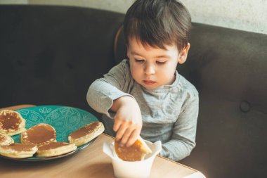 Masada lezzetli gözlemeler yiyen beyaz bir çocuk kremayla denedi.