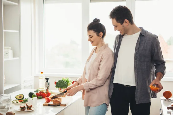 Giovane coppia caucasica preparare il cibo insieme in cucina affettare frutta e verdura — Foto Stock