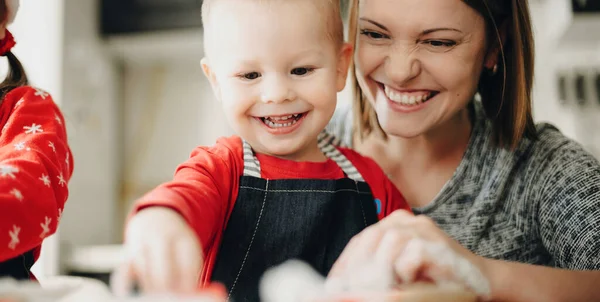 Feliz madre caucásica con hijo preparándose para la comida de Navidad horneando galletas en casa juntos — Foto de Stock