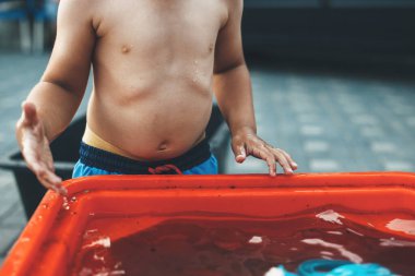 Bir yaz günü bahçesinde tişörtsüz oynayan beyaz bir çocuğun yakın plan fotoğrafını çek.