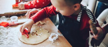 Xmas hazırlıkları sırasında form kullanarak kurabiye yapan küçük bir çocuğun üst görünüm fotoğrafı.