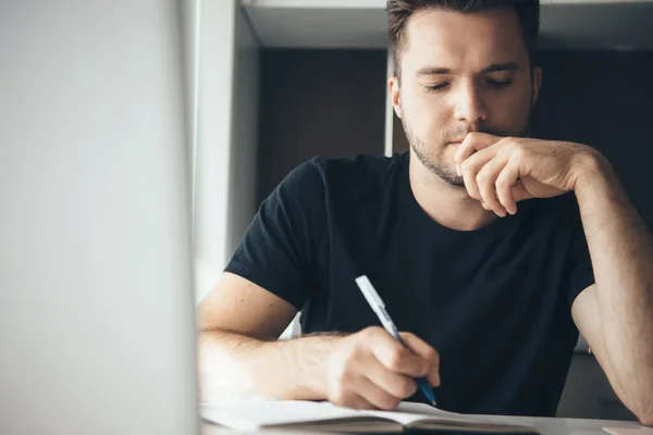 Tankeväckande kaukasisk man koncentrerad på arbete är att skriva något när du arbetar hemifrån — Stockfoto