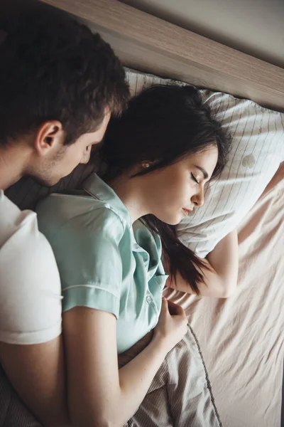 Couple caucasien couché dans le lit dormir ensemble embrassant l'autre — Photo