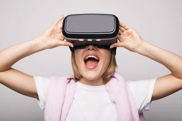 Close up foto de uma mulher loira com vr headset gesturing surpresa em uma parede de estúdio branco — Fotografia de Stock