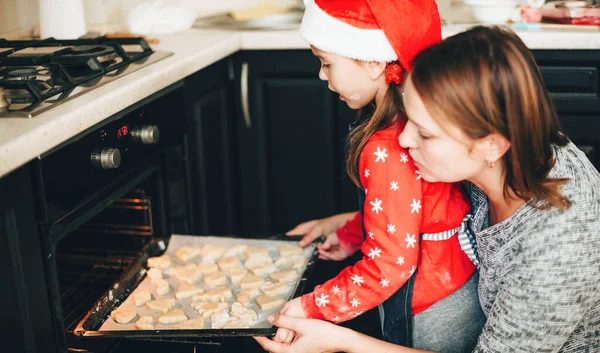 Preparación de Navidad por una familia caucásica cocinando pasteles en el horno con ropa roja de vacaciones — Foto de Stock