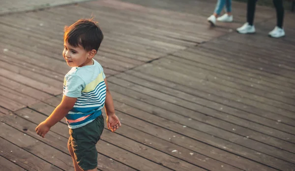 Mutlu beyaz bir çocuk ailesiyle dışarı çıkıyor ve onlara gülümsüyor. — Stok fotoğraf