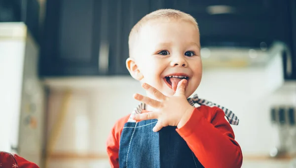 Menino caucasiano pequeno em roupas vermelhas do Papai Noel sorrindo para a câmera enquanto uma preparação xmas — Fotografia de Stock