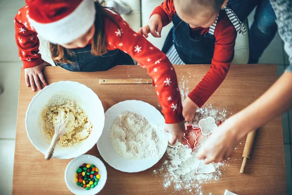 Foto vista superior de niños haciendo galletas usando harina y masa para Navidad usando ropa de santa —  Fotos de Stock