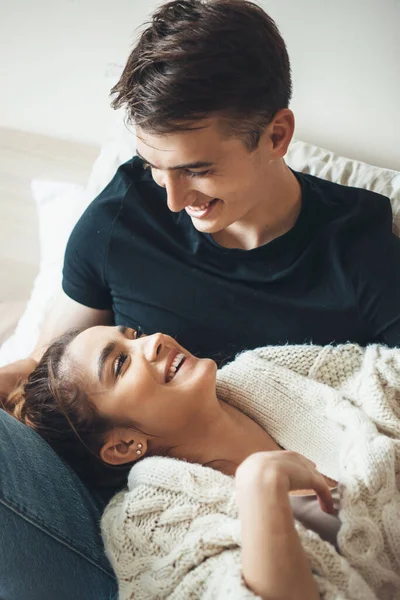 Affascinante signora bruna guardando il suo amante mentre sdraiato sulle ginocchia e sorridere indossando un maglione a maglia — Foto Stock