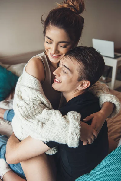 Кавказька жінка обійняла свого коханця під час гри в ліжку рано вранці в в'язаному светрі посміхаючись з закритими очима — стокове фото