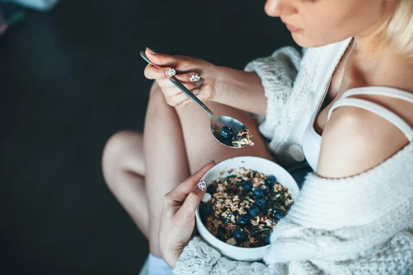 Vue supérieure photo d'une femme caucasienne dans un pull tricoté mangeant des céréales avec des baies à la maison — Photo