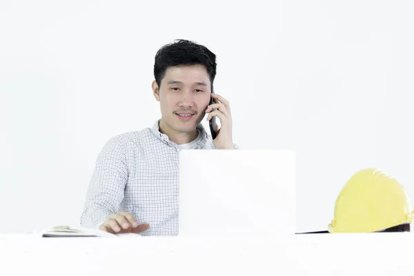 Asian employee engineer salary man sitting at desk and talking with phone, isolated on white background.