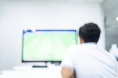 Bir adam mola zaman ve iş ofisinde rahatlatıcı zaman televizyon üzerinden fooball izliyor.