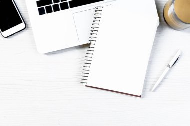 Üst görünümde çalışmak ve uzayı kopyalamak için bir sürü ekipman içeren beyaz ahşap ofis masası..